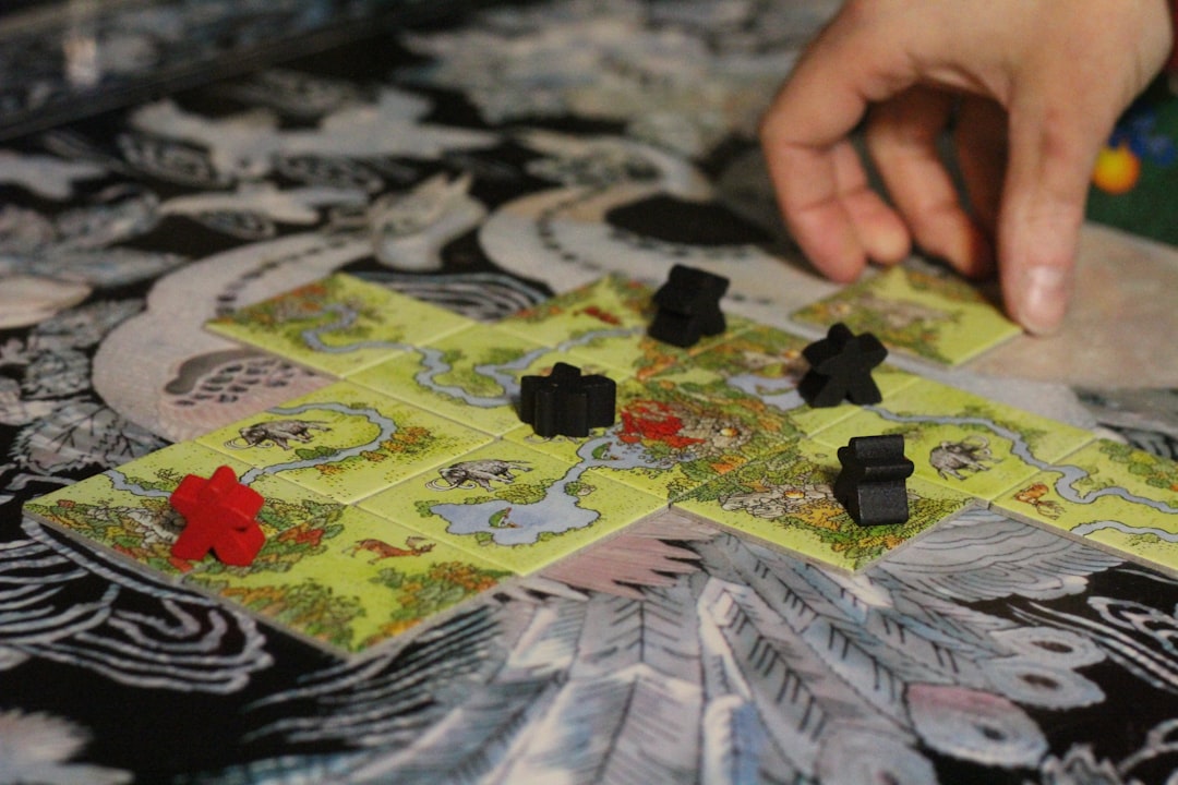 Carcassonne tile placement game board with meeples claiming features