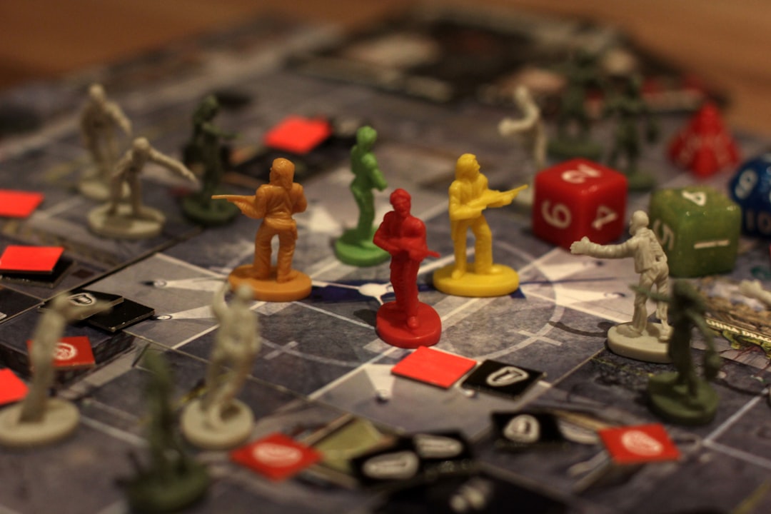 A Codenames game board showing a 5x5 grid of words with a clue card reading 'forest, two' and a guesser pointing to a card.